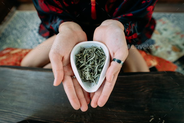 Young woman holding a small bowl of green herbal tea - Stock Photo - Images