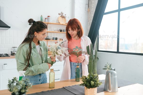 Two young women make bouquets at home in the kitchen - Stock Photo - Images