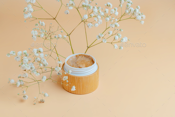 Natural body scrub on beige background. Cosmetic face cream bamboo container with care cruelty-free