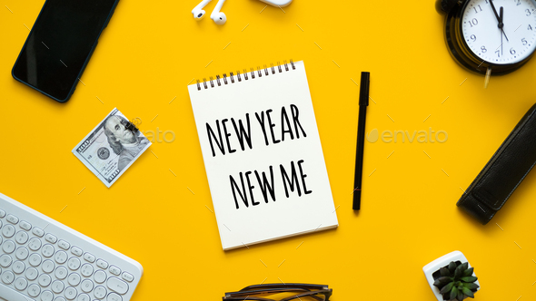 New year new me text in open notepad on yellow background. Setting goals and new years resolution