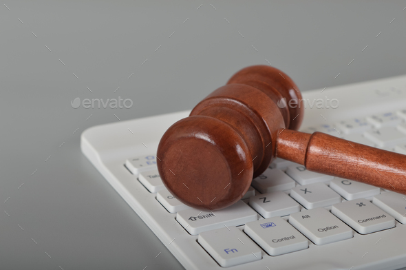 Judge gavel and laptop keyboard. Copy space. Online scam, fraud, arrest and criminal concept.