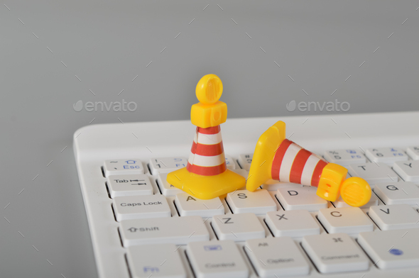 Traffic cones and laptop keyboard. Website maintenance,programming, repair, coding,under maintenance