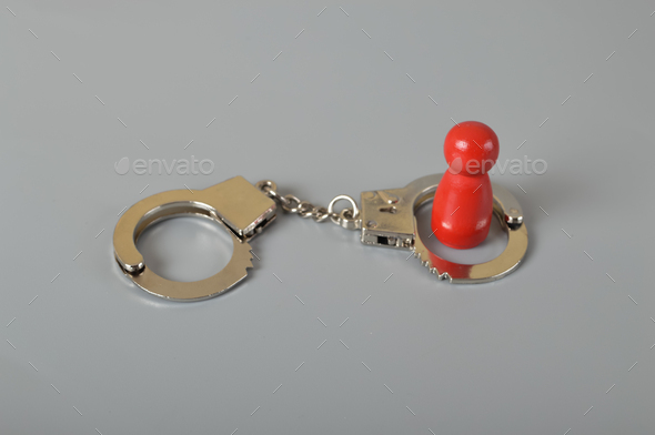 Red wooden people of figure with handcuff locked.Handcuffed convict,law offender and justice concept
