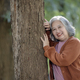 portrait of retirement women lean against the tree with happiness emotion - PhotoDune Item for Sale