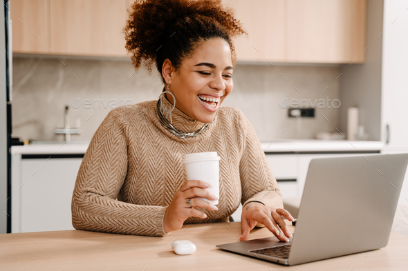 Young beautiful happy smiling african woman with coffee and laptop - Stock Photo - Images