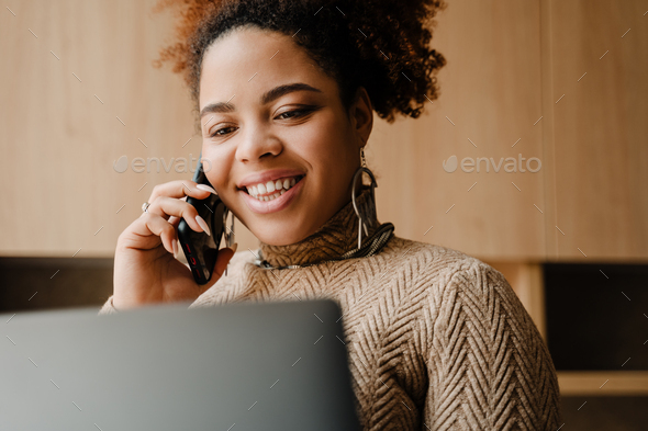Young beautiful smiling african woman talking on her phone - Stock Photo - Images