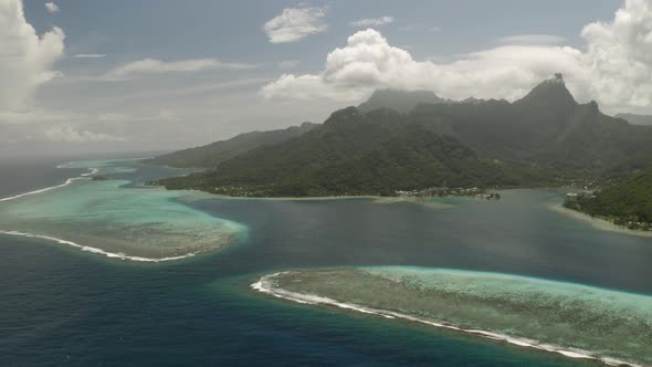Aerial dolly left shot of Mo'orea island surrounded by barrier reef in French Polynesia alt