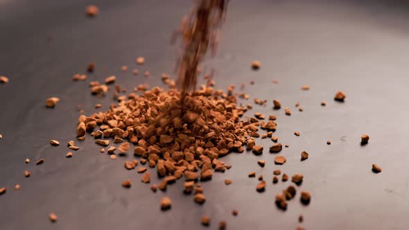 Instant Coffee Granules Drop in Slow Motion Onto a Black Surface and Form a Small Pile