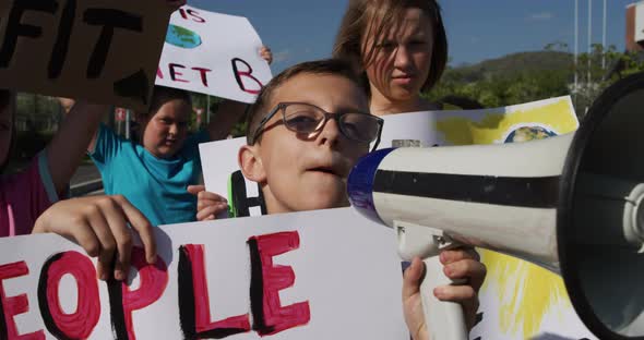 Group of kids with climate change signs and megaphone in a protest alt