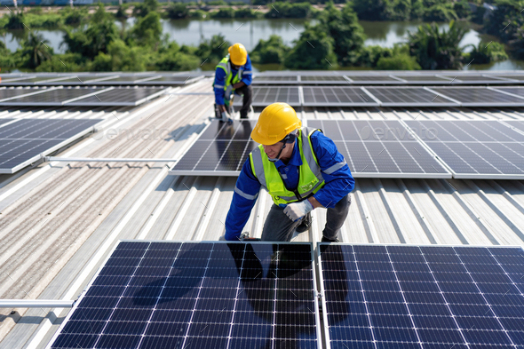 Engineer on rooftop kneeling next to solar panels photo voltaic with ...