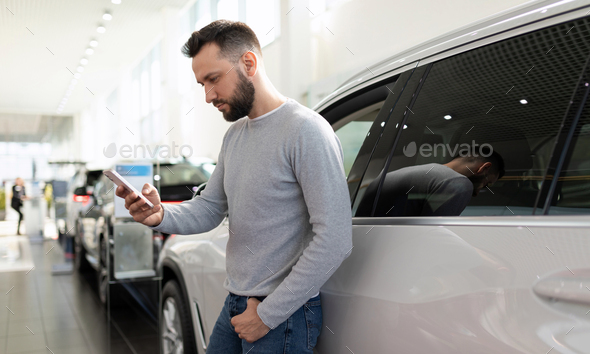 a man in a car dealership chooses a car and an insurance policy for it