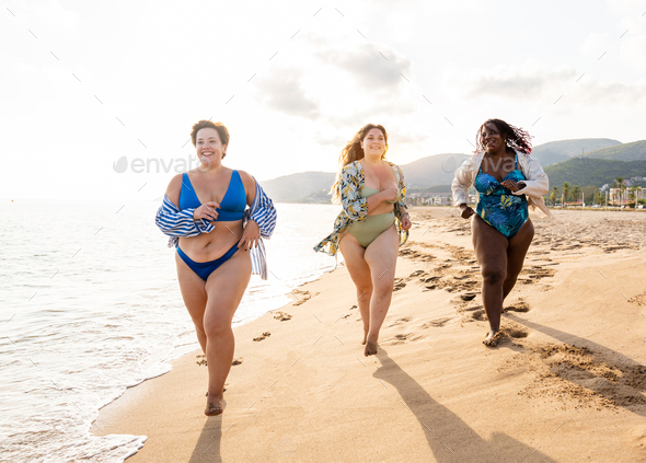 Group of beautiful plus size women with swimwear bonding and having fun at  the beach - Group