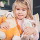 Little girl smiling and hugging two plush toys dog and cat. - PhotoDune Item for Sale