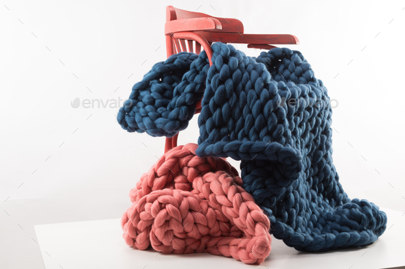 a rough knit blanket thrown over a chair concept of comfort and warmth in the house