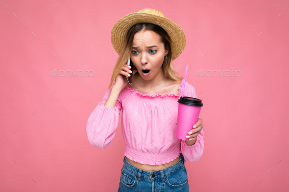 Photo of beautiful shocked amazed emotional young blonde woman wearing pink crop blouse and straw
