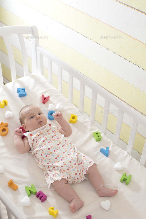 Baby in a baby bed. - Stock Photo - Images