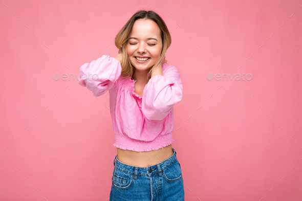 Portrait of young beautiful smiling hipster blonde woman in trendy pink crop top blouse. Sexy