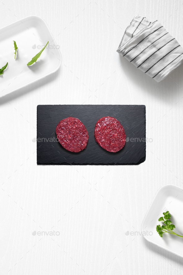 Beef burguers on a kitchen with some herbs - Stock Photo - Images