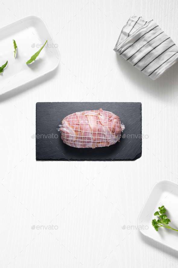 Beef roti with bacon on a kitchen with some herbs - Stock Photo - Images