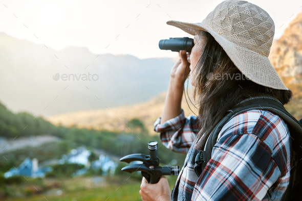 Hiking, exploration and mountain adventure with binoculars, trekking pole and walking aid in a remo