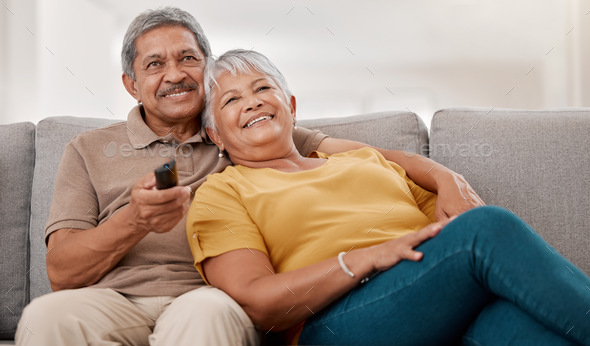Senior people gadgets in room. Happy elderly couple on sofa in