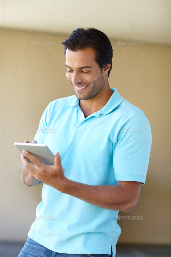 Downloading a new app. Shot of a handsome man using a digital tablet indoors. - Stock Photo - Images