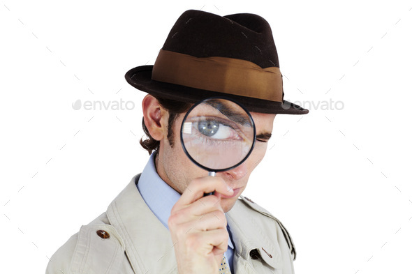 Curious private investigator looking through a magnifying glass against a white background