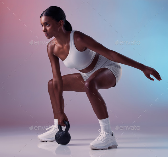 Fitness, exercise and woman with a kettlebell in studio strength training and burning calories in a