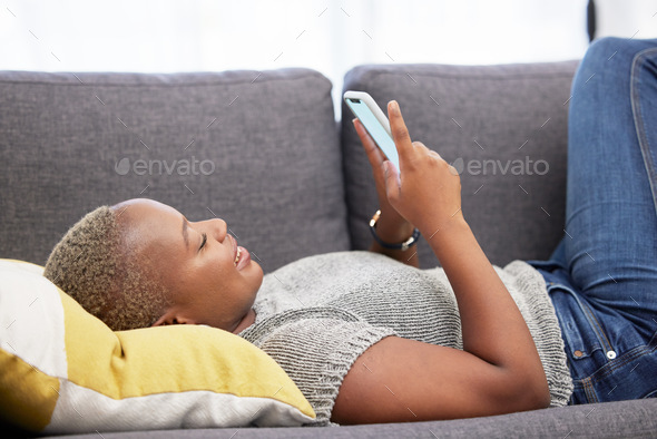 Black woman with smartphone, social media and technology with communication and relax on sofa at ho - Stock Photo - Images