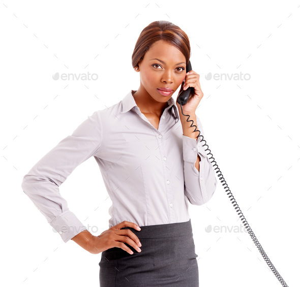 An unhappy customer. An upset business woman with her hands on her hip talking on the phone.