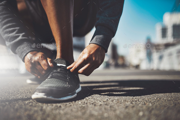 The best project youll ever work on is you. Shot of a sporty man tying his laces before a run.