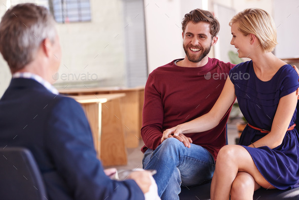 Their investments are growing. Young couple discussing investment plans with a financial advisor. - Stock Photo - Images