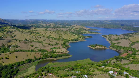 Aerial view of beautiful idyllic landscape with river and Bao Dam during sunny day on Dominican Repu alt