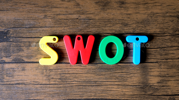 Word SWOT from wooden letters on dark wooden background