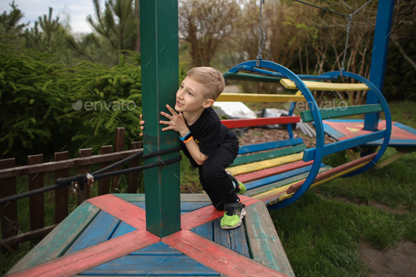 the boy passes an obstacle course is engaged in an active sport climbed on a wooden platform