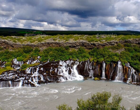 Hraunfossar waterfall with a cloudy sky in the background on a gloomy day, Island - Stock Photo - Images