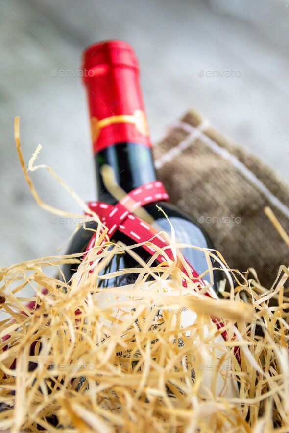 Vertical shot of a bottle of wine with ribbon and decorative straw