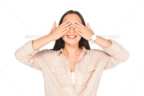 smiling woman showing see no evil gesture while posing at camera isolated on white