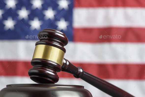 Close up of wooden judge gavel. American flag in background - Stock Photo - Images
