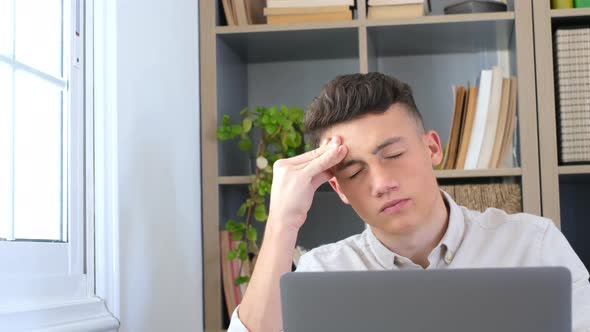Unhealthy stressed young man suffering headache at home because overwork and studying hard