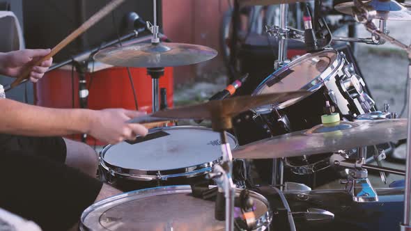 A drummer playing a drum kit. Hit the snare drum, head and cymbals with sticks alt