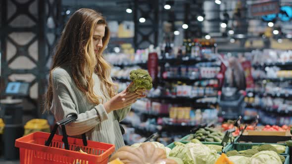 Female Caucasian Woman Female Shopper Consumer Chooses Healthy Tasty Vegetables Holding Green alt