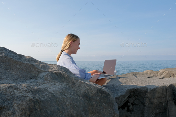 Remote work.Girl freelancer works remotely on the sea shore. workation, remote work,WFVH,Van Life vi