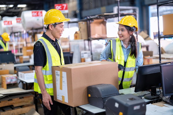 2 Staff working in large depot storage warehouse check packing box and scan at cashier counter