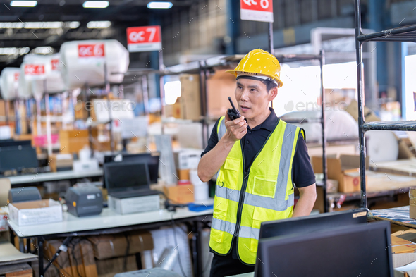 Worker working in large depot storage warehouse hold radio walkie talkie to team at cashier counter