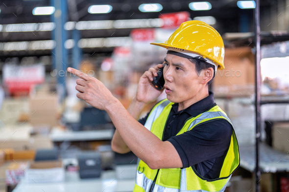 Worker working in large depot storage warehouse hold radio walkie talkie to team at cashier counter