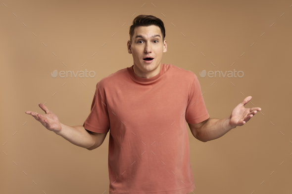 Astonished man wearing casual style T-shirt, standing with mouth open in surprise