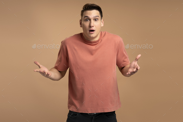 Astonished man wearing casual style T-shirt, standing with mouth open in surprise