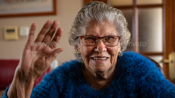 Portrait of happy caucasian 90s woman enjoying video call talk. Hand hello