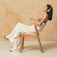 Profile view of stylish female resting on chair enjoying music in headphones, using phone app - PhotoDune Item for Sale